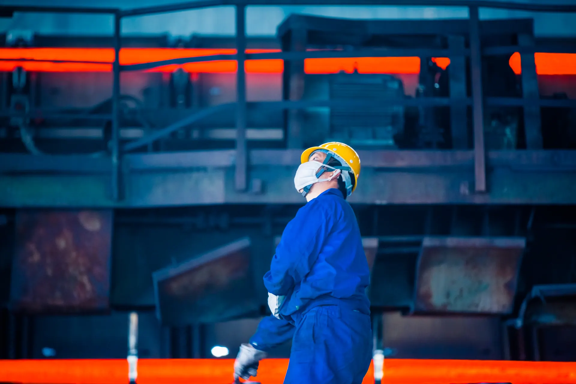 Worker in protective gear inside an industrial facility